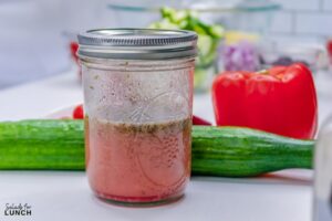 Close up of greek salad dressing in a mason jar.