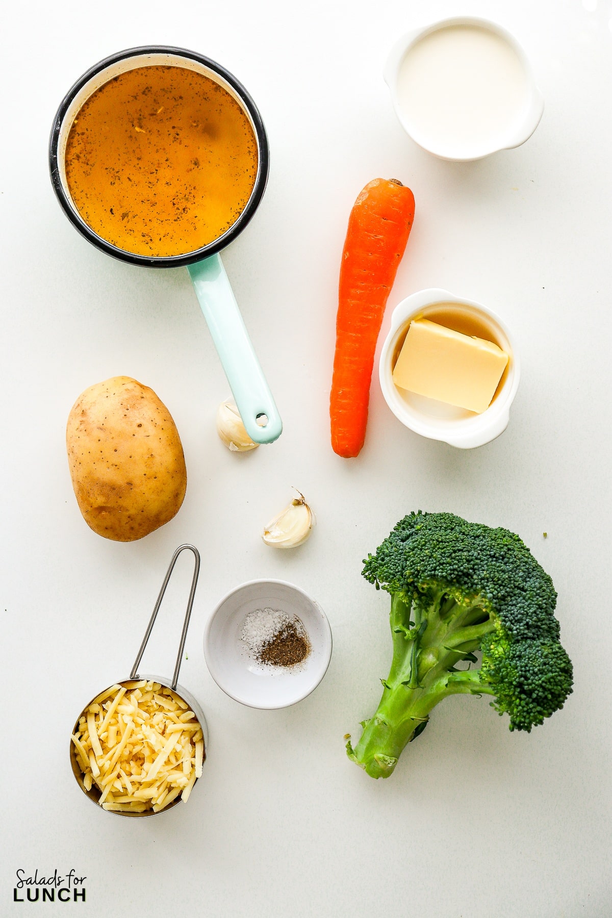 Ingredients for broccoli cheddar soup spread out on a white table.