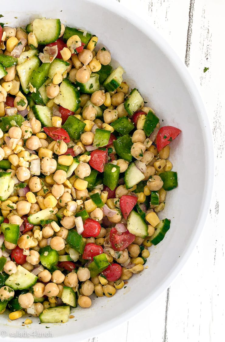 Cilantro lime chickpea salad in a white bowl on white wood countertop