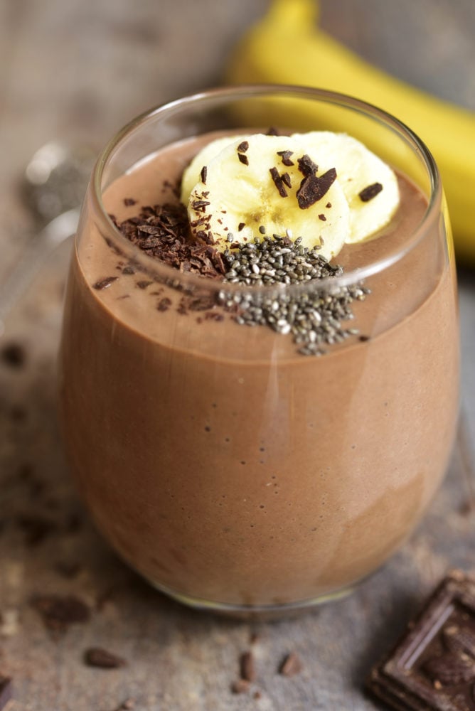 Chocolate banana smoothie with chia seed on a rustic table.