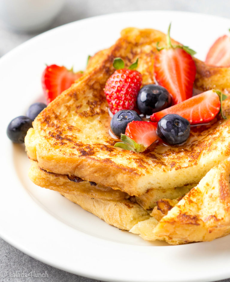 French toast with berries (blueberries, strawberries) and sauce, traditional sweet dessert of bread with egg and milk. Morning baking food.