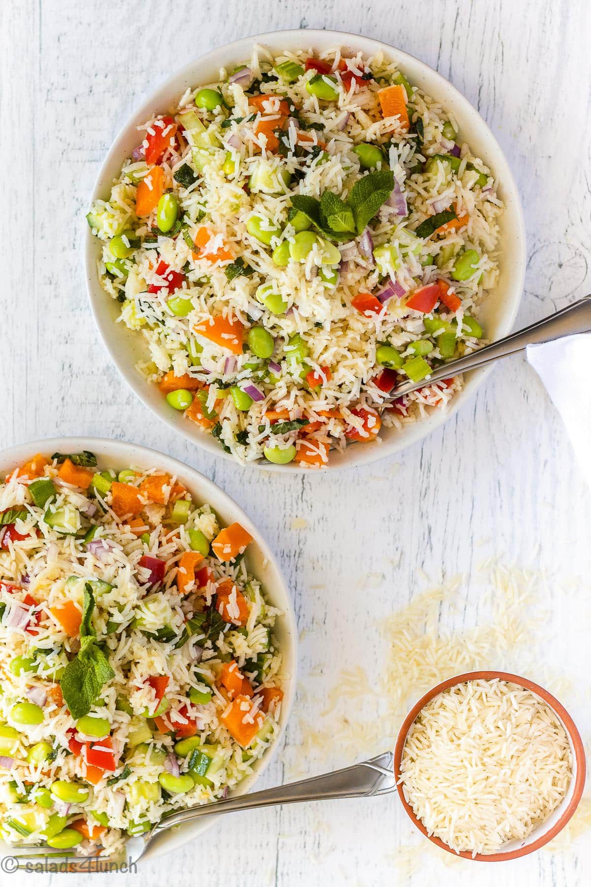 Two white bowls with Basmati Rice salad in them on a white board. 