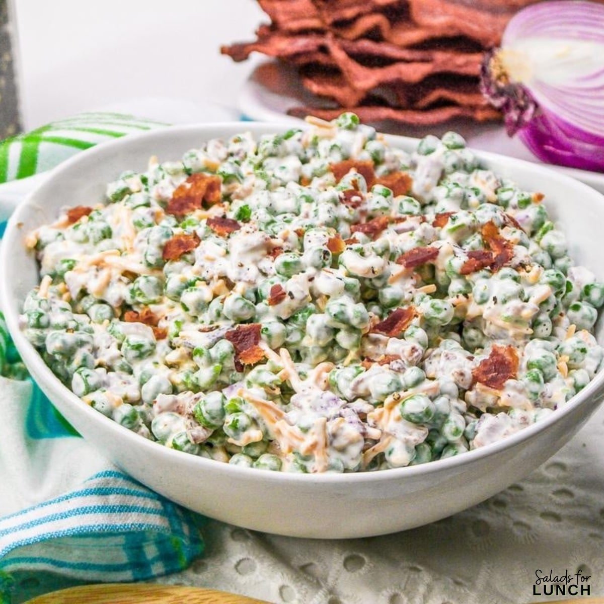 Creamy Green Pea Salad with bacon onion and cheese - Spring is officially in full bloom, and that means it’s time to celebrate all the amazing spring salad ingredients May has to offer! 🌷💚 From sweet strawberries to crisp asparagus, the produce aisle is bursting with color—and flavor. And what better way to use all that seasonal goodness than in a delicious salad?