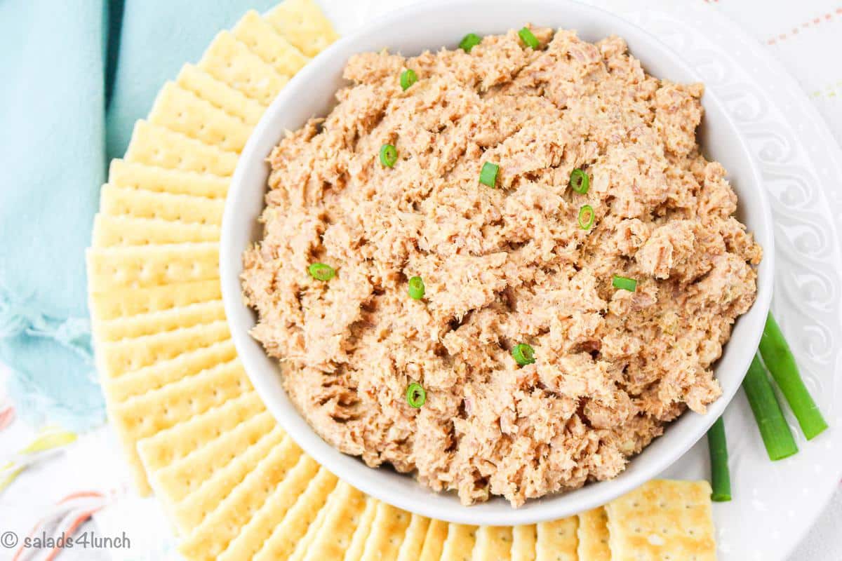 Overhead close up of deviled ham salad in a white bowl garnished with green onion.