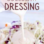 Creamy Coleslaw dressing being poured over coleslaw in a white bowl with grapes and sunflower seeds with text overlay that says: "Easy Creamy Coleslaw Dressing".