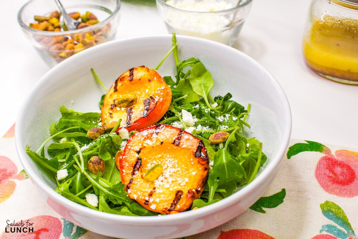 Grilled Peach Summer Salad 11 - Indulge in the flavors of the season with our Grilled Peach Summer Salad! Arugula and pistachios complement the juicy peaches, creating a refreshing and elegant dish perfect for your late summer BBQs. Get ready to savor the taste of sunshine!