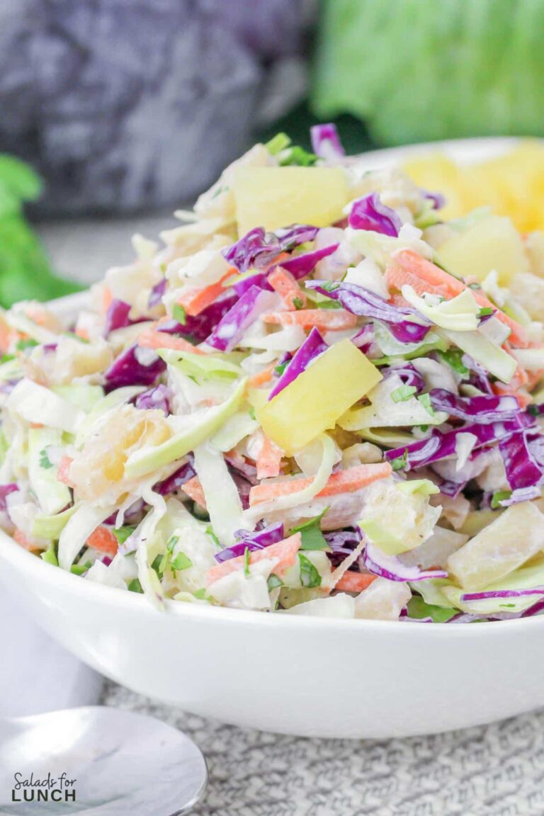 Close up of colourful hawaiian coleslaw with pineapple in a white bowl.