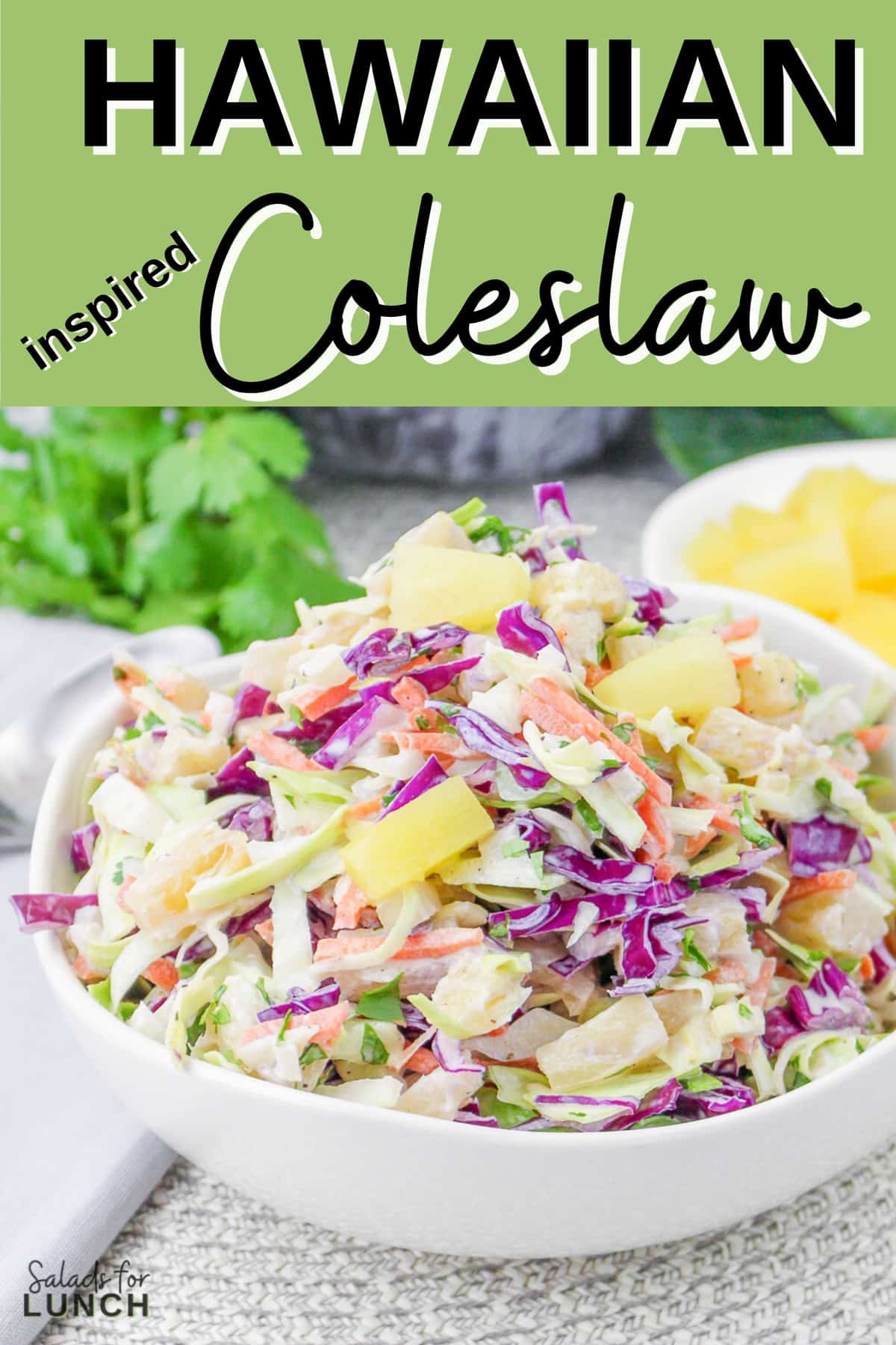 Close up of colourful hawaiian coleslaw with pineapple in a white bowl with text overlay that says "Hawaiian Inspired Coleslaw".