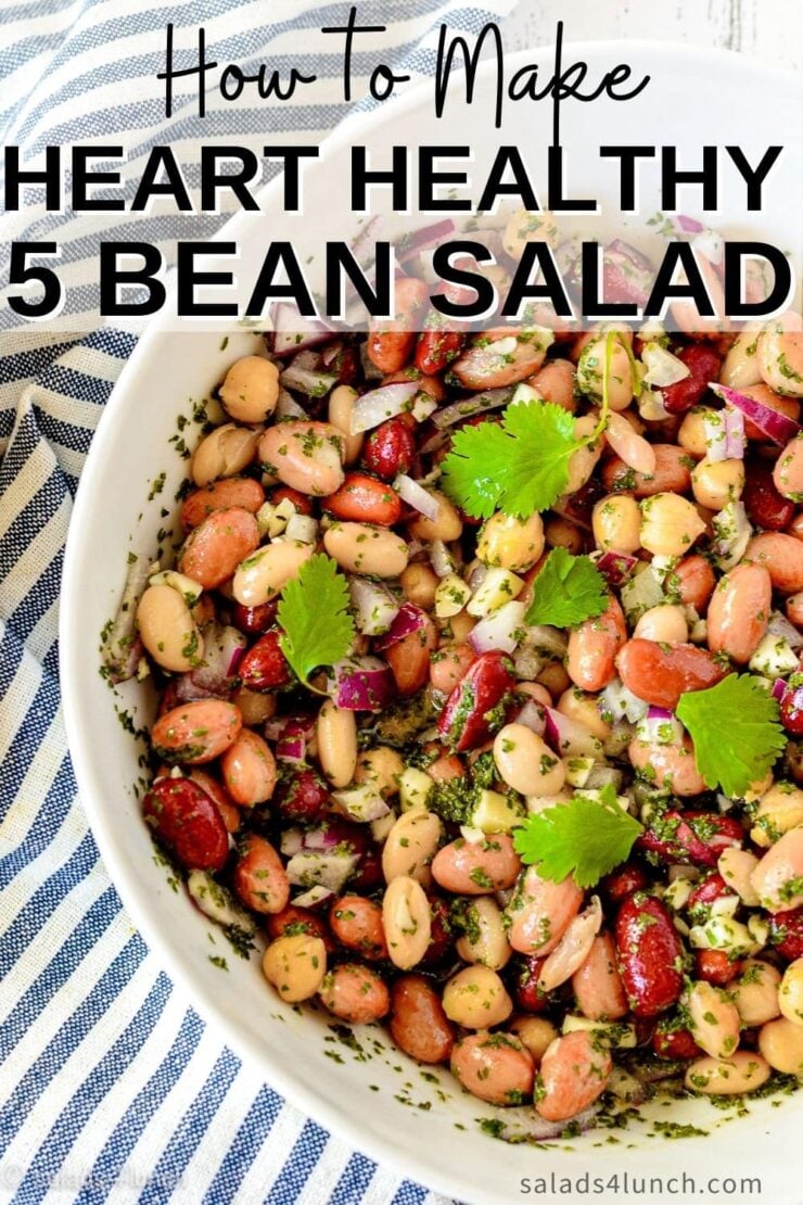 Close up of a white bowl with five bean salad in it on a blue and white striped napkin.