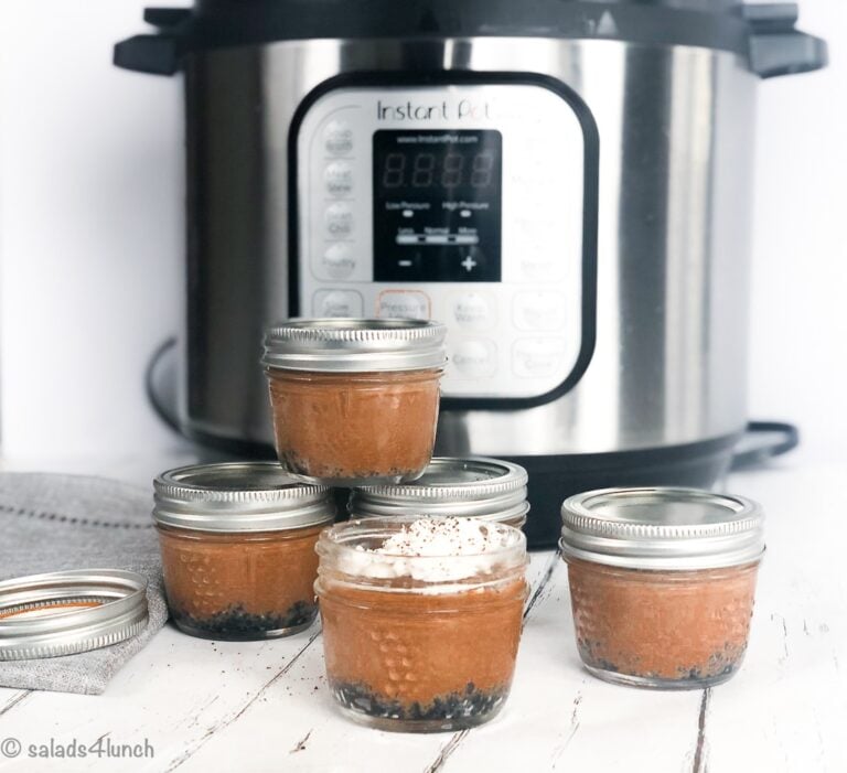 Stacked mini mason jar chocolate cheesecakes in front of an Instant Pot