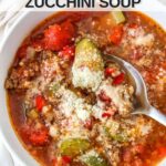 Close up of white bowl with low carb zucchini soup in it, the soup is sprinkled with parmesan cheese.