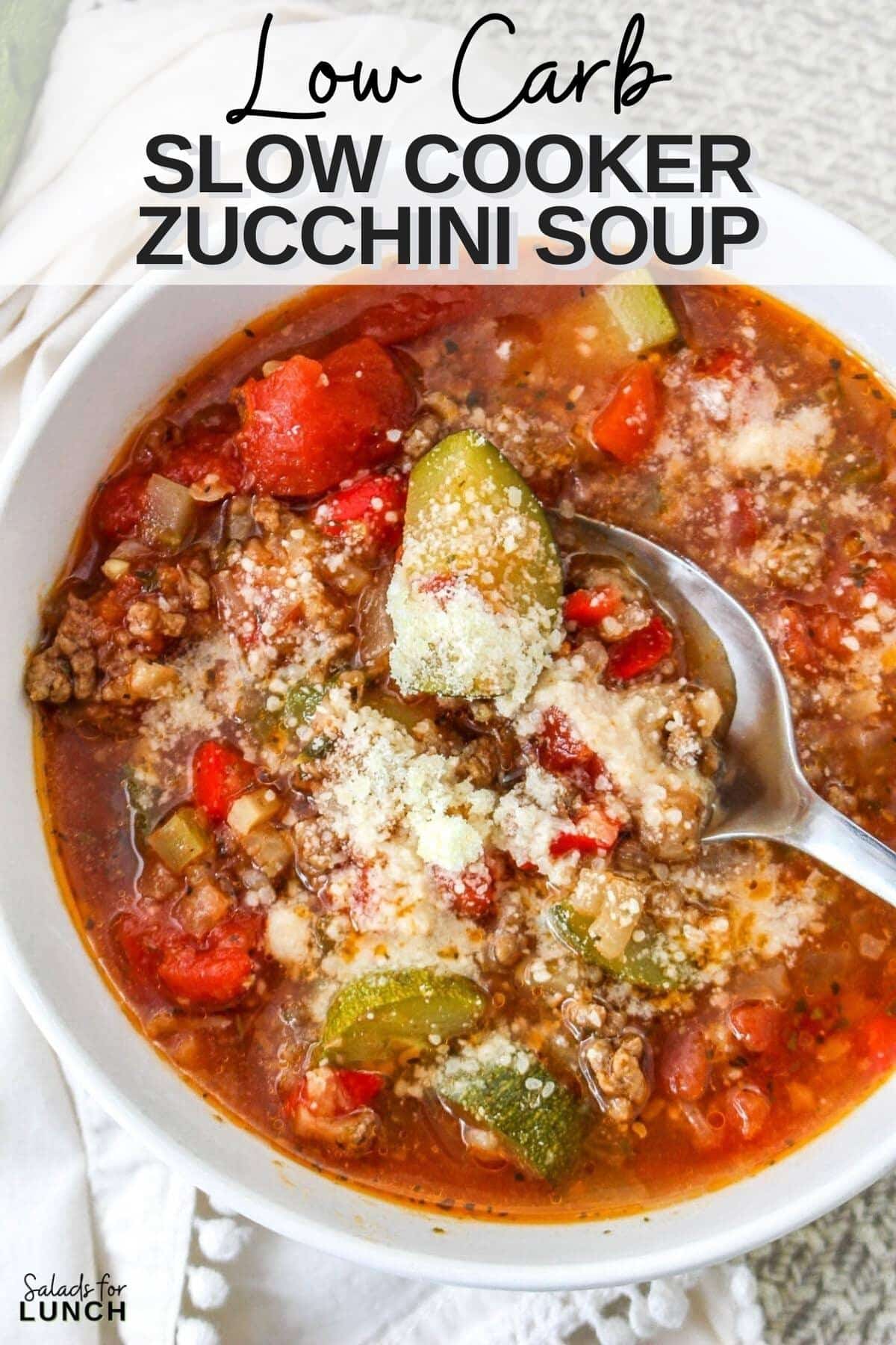 Close up of white bowl with low carb zucchini soup in it, the soup is sprinkled with parmesan cheese.