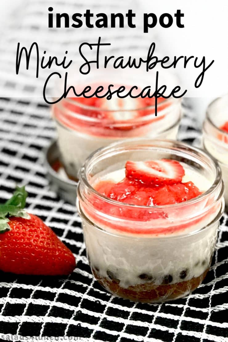 Close up of strawberry cheesecake in a mini mason jar with text overlay that says "Instant pot mini strawberry cheesecake".