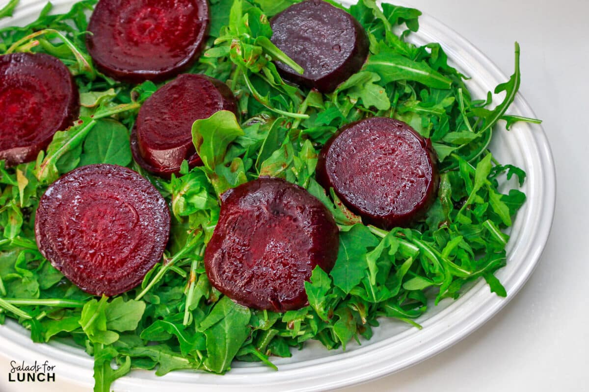 Roasted Beet Salad Recipe 12 1 - With the festive hues of red beets, green arugula, and golden slivered almonds, this Christmas salad recipe is a celebration of flavors and a feast for the eyes that will make your holiday spread merry and bright!