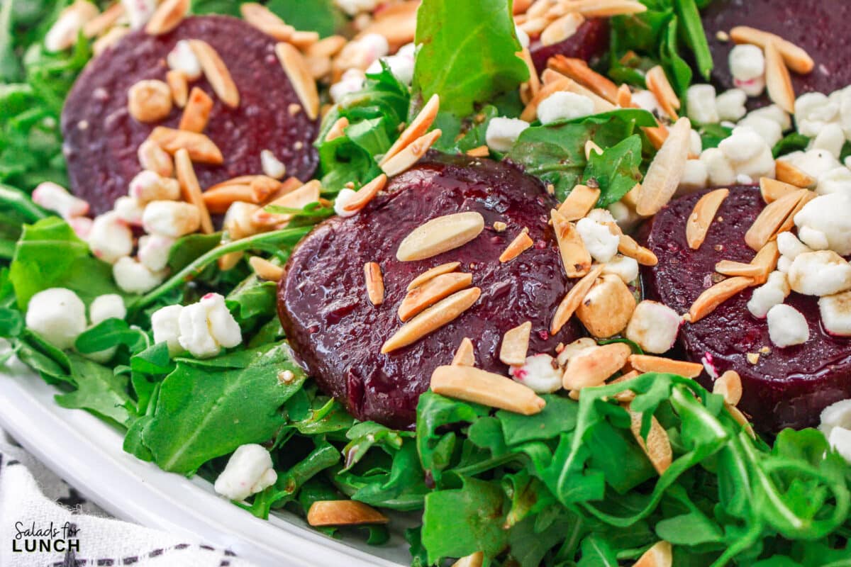 Roasted Beet Salad Recipe 18 1 - With the festive hues of red beets, green arugula, and golden slivered almonds, this Christmas salad recipe is a celebration of flavors and a feast for the eyes that will make your holiday spread merry and bright!
