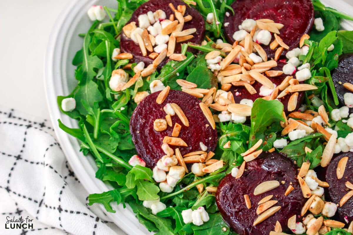 Roasted Beet Salad Recipe 26 1 - With the festive hues of red beets, green arugula, and golden slivered almonds, this Christmas salad recipe is a celebration of flavors and a feast for the eyes that will make your holiday spread merry and bright!