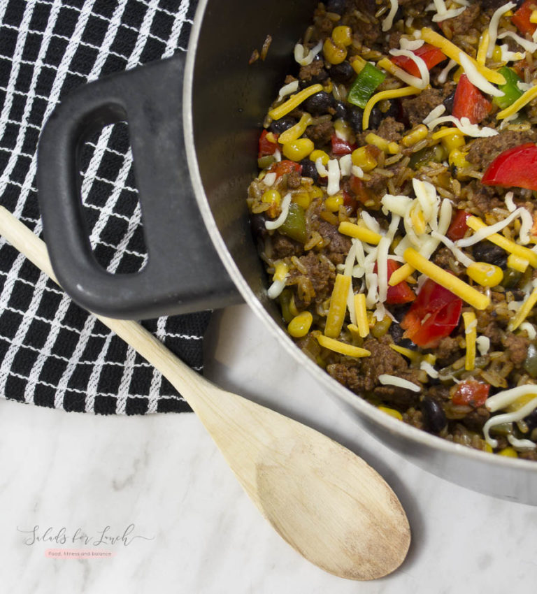 Spanish Rice dinner in a pot with wooden spoon