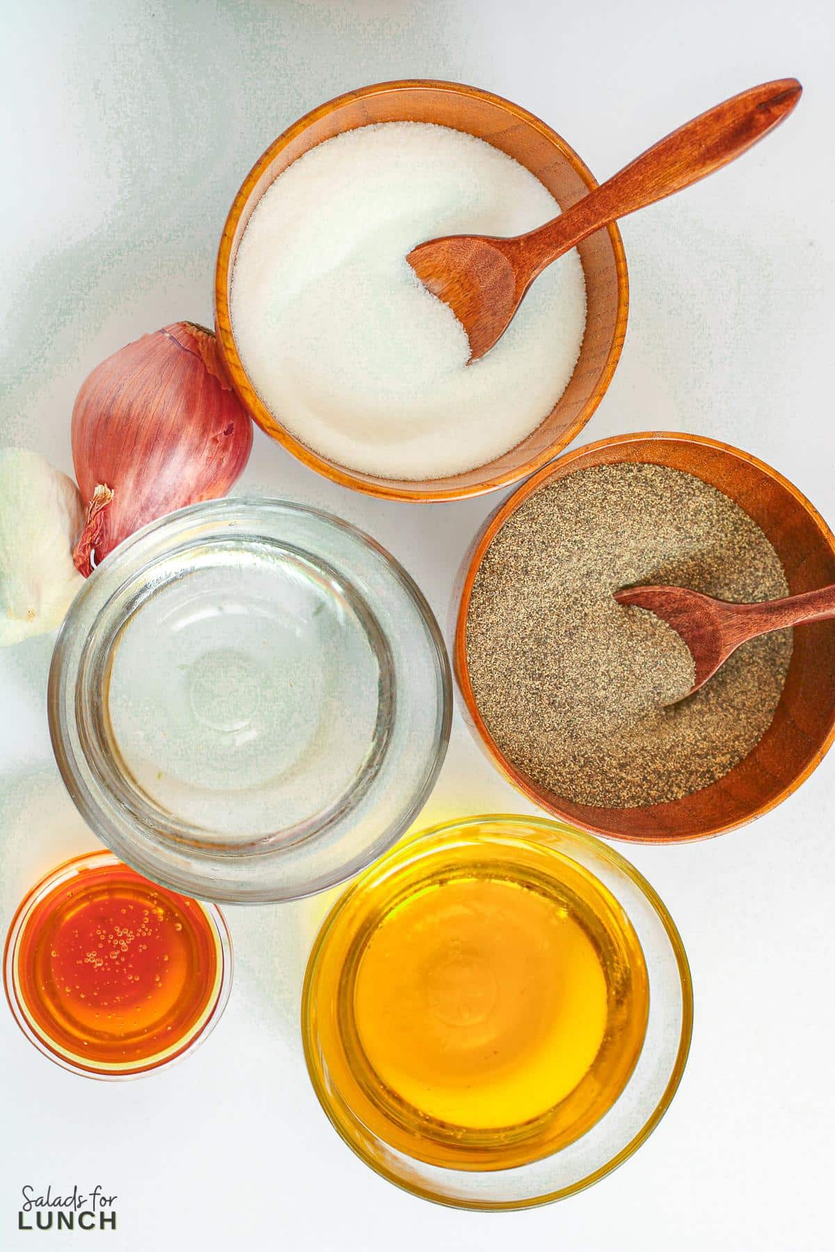 Overhead photo of the ingredients needed to make white balsamic vinaigrette dressing in small pinch bowls.