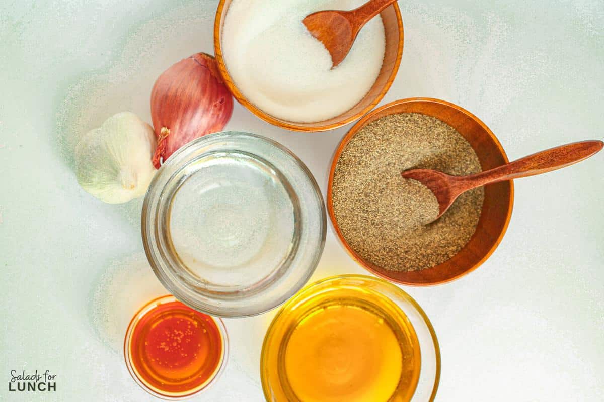 Overhead photo of the ingredients needed to make white balsamic vinaigrette dressing in small pinch bowls.