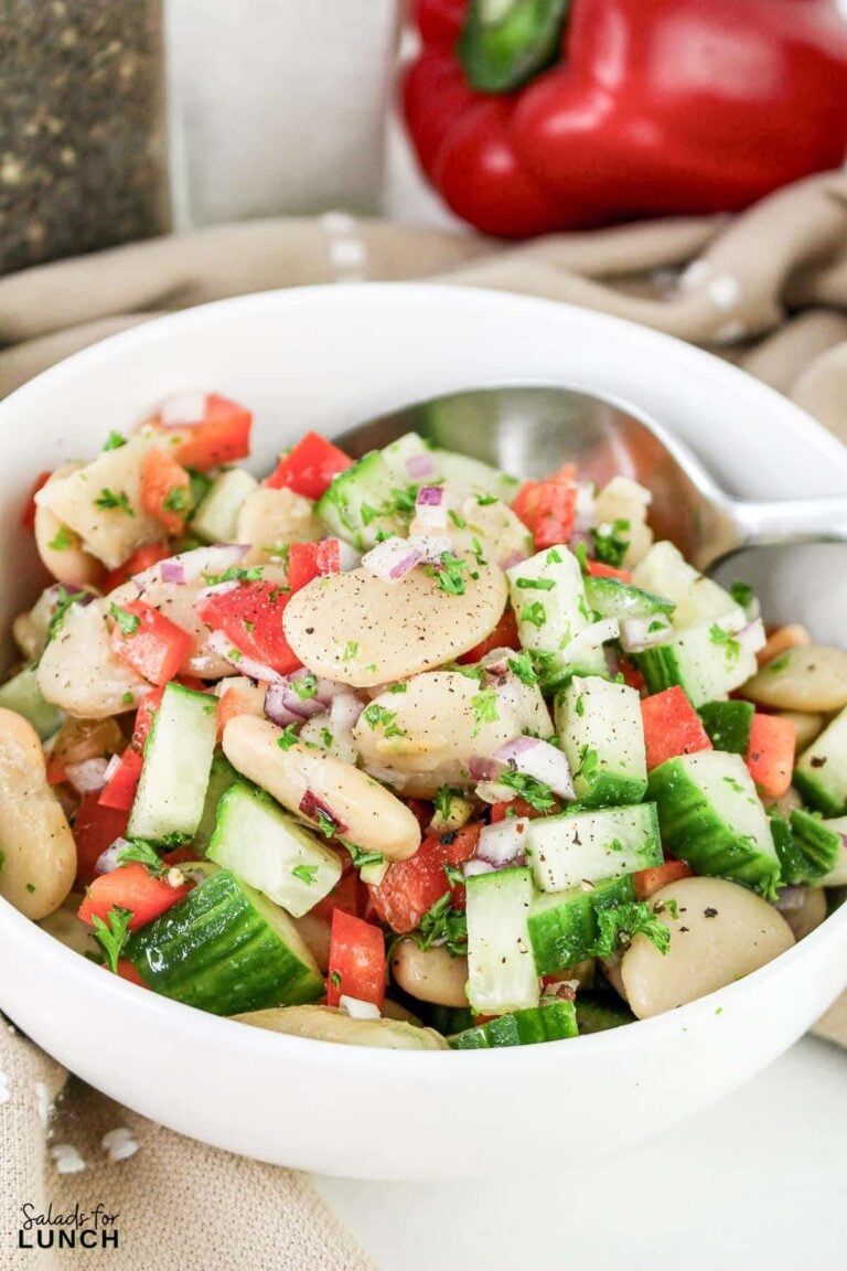 A bowl of butter bean salad with a spoon.