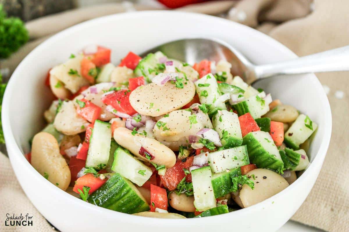 A bowl of Summer Butter Bean salad with a spoon.