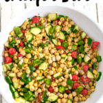 Cilantro lime chickpea salad in a white bowl on white wood countertop