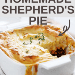 Close up photo of shepherd's pie in a white square casserole dish with a twig of thyme on top and one small piece missing.