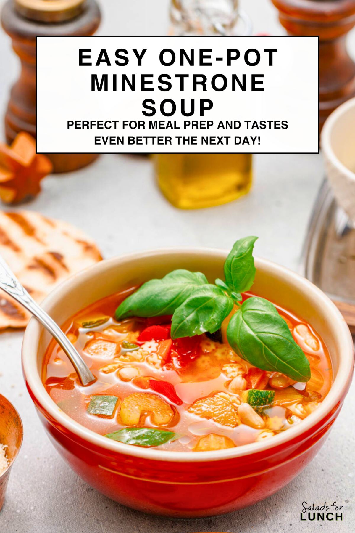Close up of minestrone soup in a red bowl that's white inside to show off the vibrant colours of the minestrone soup.